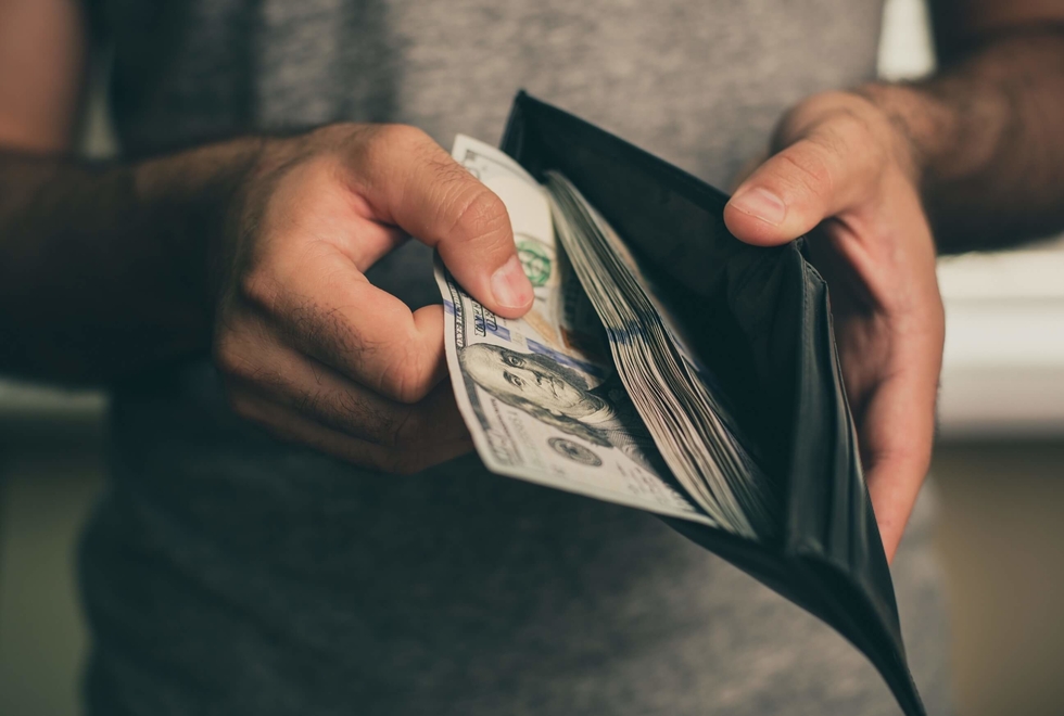 A photo of a person taking money from a wallet