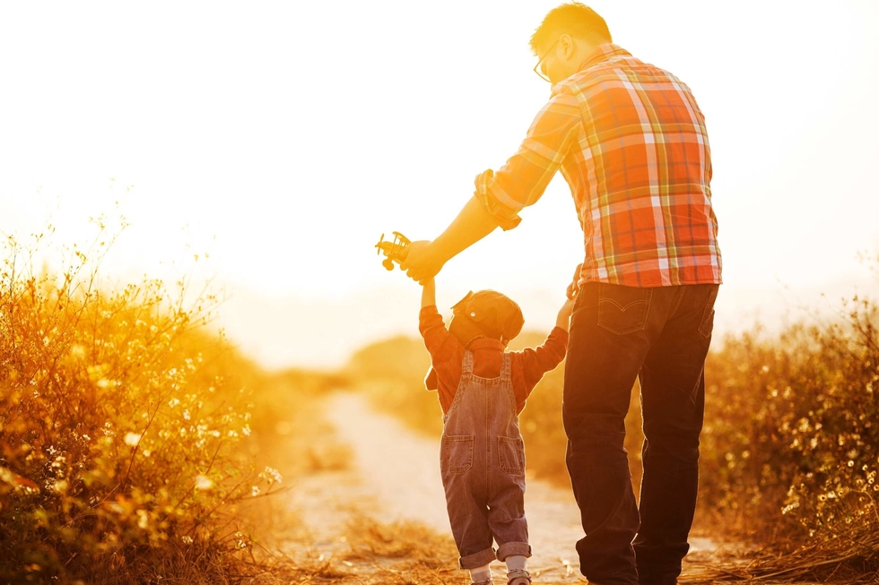 Father and son againts a sunset