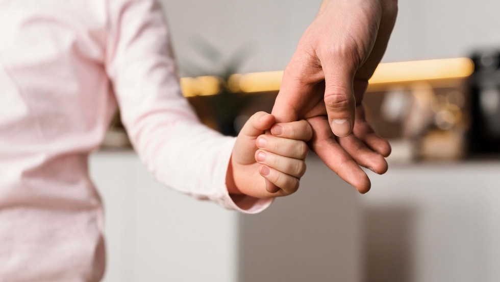 Father and young daughter holding hands